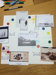 Board with counters in a circle and postcards of artic scenes including penguins, sleds, and seals