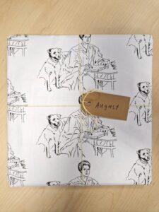 A photo showing August's prize wrapped in paper with his illustration of Jessie MacLaren MacGregor printed on it.