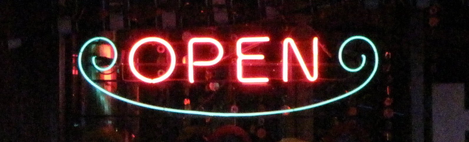 Pink and blue neon open sign against a black background