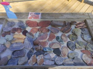 Numbers of rocks in an open box, placed on an table outside.