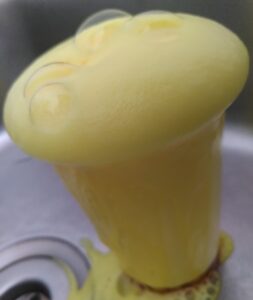 A photo of yellow foam bubbling out of a plastic cup