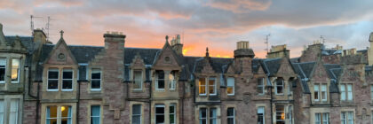 Cloudy sunset behind buildings