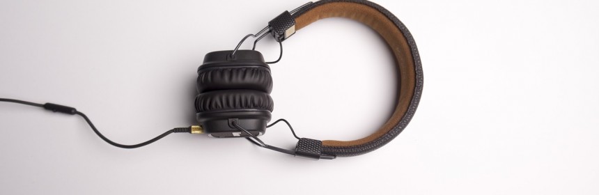 White background with a pair of brown over-ear full sized headphones